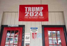red political banner above two red doors on a storefront