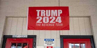 red political banner above two red doors on a storefront