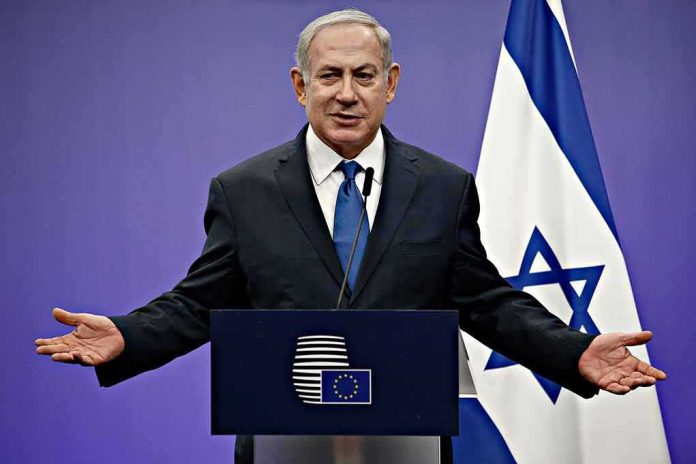 shutterstock_1046491414 man in suit speaking at a podium with Israeli flag