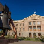 Large bronze bell in front of a neoclassical government building