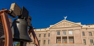 Large bronze bell in front of a neoclassical government building