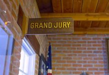 Juror Held in Safehouse- ATTACKED For Being Republican Grand jury sign in a brick-walled hallway