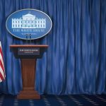 Trump Assassination Plot THWARTED – See Who Planned Attack White House press briefing podium with U.S. flag and blue curtain