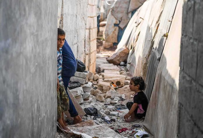 children in a narrow alley with rubble