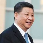 Xi Wraps Up U.S Tour With Bizarre Final Stop man in suit smiling outdoors