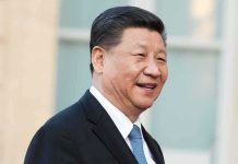 Xi Wraps Up U.S Tour With Bizarre Final Stop man in suit smiling outdoors