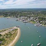 Aerial view of a coastal harbor with boats and a seaside town