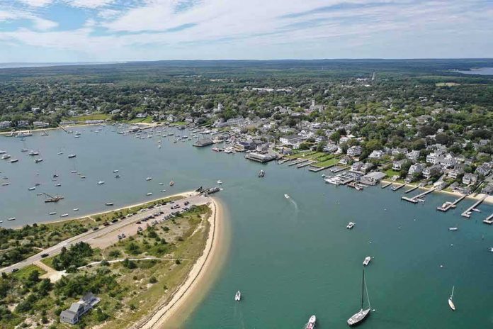 shutterstock_1418157551 Aerial view of a coastal harbor with boats and a seaside town