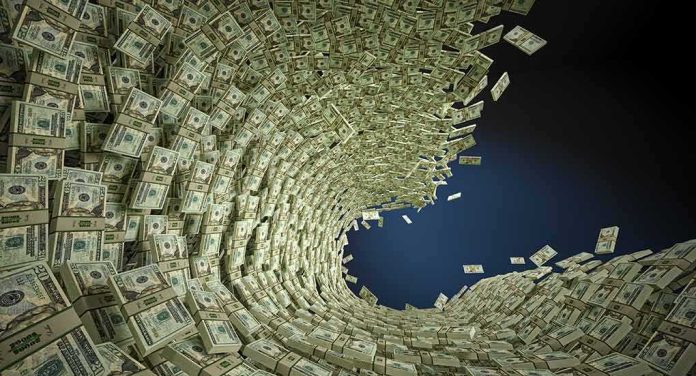 shutterstock_150180902 Tornado of US dollar bills swirling into a vortex