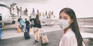 Woman in face mask at airport boarding gate