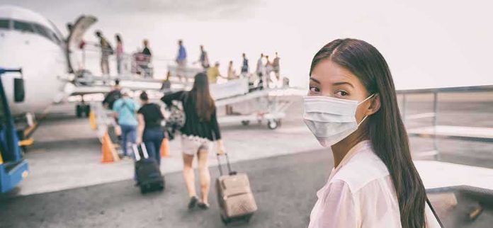 Woman in face mask at airport boarding gate