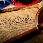 U.S. Constitution with gavel and flag