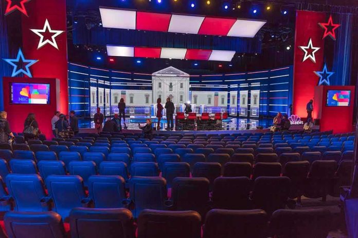 shutterstock_1656995731-2 Debate stage with red and blue lighting and empty audience seats