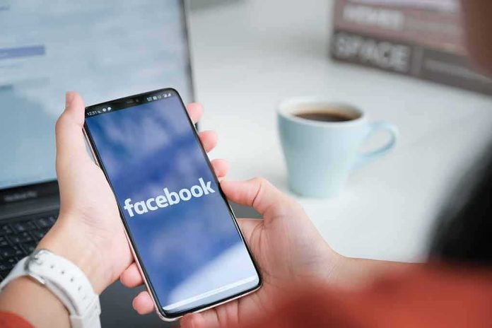 Person holding smartphone with Facebook app open