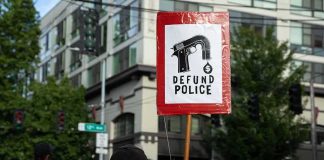 Protesters holding a red sign in a city street