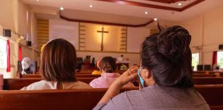 Talarico Creates NEW INCLUSIVE BIBLE people seated in church pews facing a cross