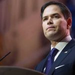 Nazi Meme Blasts Rubio’s TOP Aide man in suit speaking at podium