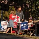 Governor Calls For Emergency Session Amid Redistricting Battle People at a campaign booth with political signs outdoors