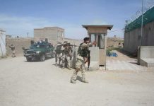 Iran Militia Strikes Tehran – Civil War Ignites Armed soldiers patrol near a guard post outside a walled compound