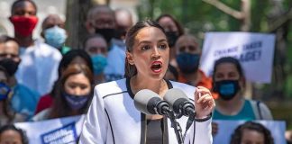 Woman speaking at outdoor podium with microphones