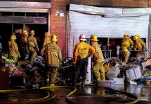 47 Fires A Day – LA On Edge Firefighters work outside a damaged warehouse with debris and hoses