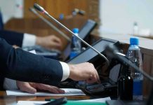 Person pressing a button on a conference microphone panel