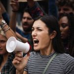 Woman with megaphone shouting at a protest