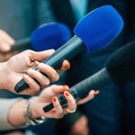 Disgraced Prime Minister Announces Resignation While In Tears Reporters holding colorful microphones