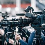 Michigan’s SHOCK MOVE: Legal Suicide Clash! Broadcast cameras on tripods at a press event