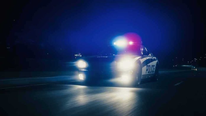 Police car with flashing lights driving at night