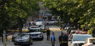 Murderous Couple Found DEAD After Quadruple Killing Police officers secure a residential street with patrol cars and yellow tape