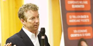 Rand Paul speaking with a microphone during an indoor event