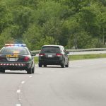 Illegal Migrant WHACKED By Semi Truck On The Run Police car with flashing lights following a minivan on a highway