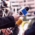 Reporter Goes VIRAL After Cockroach Infestation! Reporters hold microphones during an outdoor interview