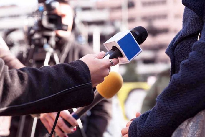 Reporters hold microphones during an outdoor interview