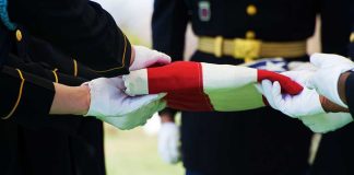 Military personnel folding a flag during a ceremonial event