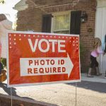 SHOCKING Trump Attack on ‘RINO’ Massie Red voting sign with arrow near people entering a polling place