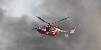 Rescue helicopter hovers amid thick smoke