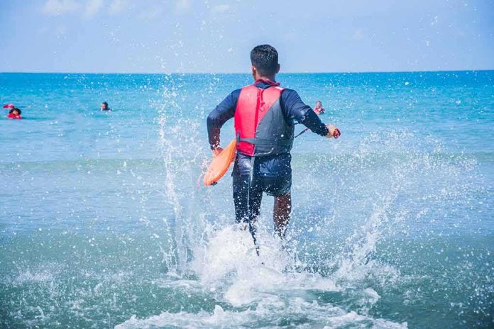 shutterstock_633531671 lifeguard wading into ocean with rescue buoy