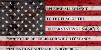 American flag with pledge text on a weathered surface