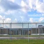 Small Cages Found Outside ICE Detention Facility Prison yard behind chain-link and razor wire fence
