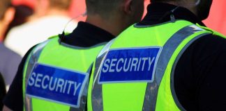 Schools Hiring Security To Protect Girls From Migrant Rapists Two security personnel wearing high visibility vests with SECURITY printed on the back