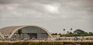 Base Imposes Curfew and Ban After Local Murder airport hangar with helicopters near a shoreline
