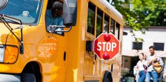 Deadly School Bus Horror Before Sunrise School bus with extended stop sign near students on sidewalk