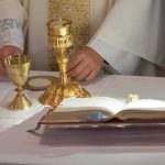 Priest at altar with chalices and open book