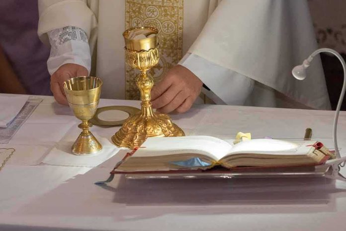 Priest at altar with chalices and open book
