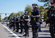 French School Chaos Ignites Nationwide Uprising Bear Pascoe, Brian Folkerts, and Eugene Sims among riot police standing in a line on a city street