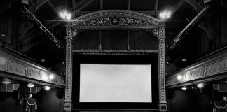 Empty ornate theater with a blank screen