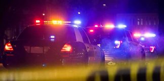 Suspect Arrested For Sexual Assault of Underage Boy is Trans Illegal Police cars with flashing lights behind yellow caution tape at night