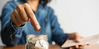 Trump Enrolls ALL Eligible Children Into His Account Person placing a coin into a savings jar labeled 'SAVINGS'